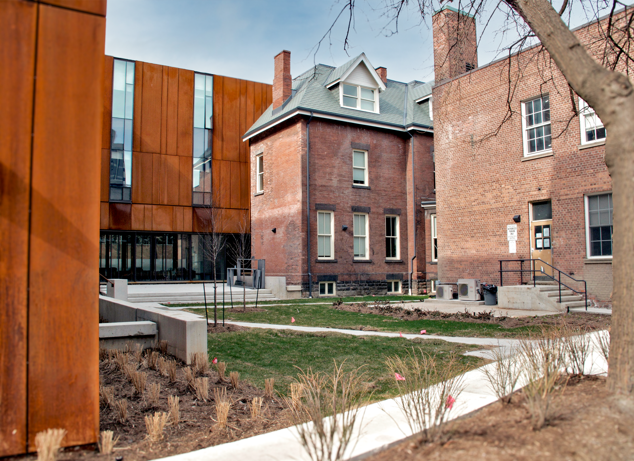 A grass courtyard with red brick buildings surrounding by rusted metal buildings