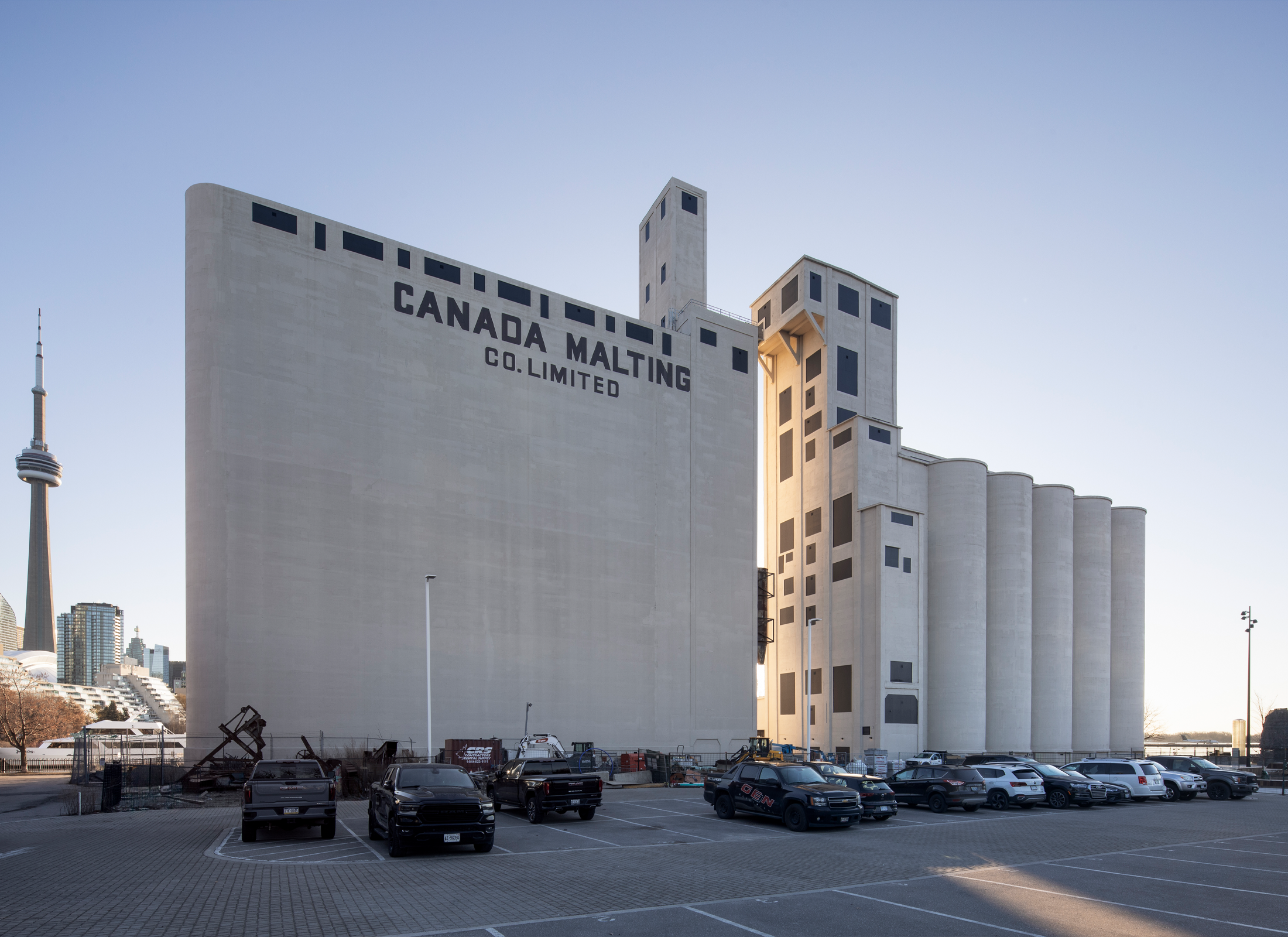 Exterior view of the Canada Malting Silo, a concrete industrial building sitting in front of a full parking lot.