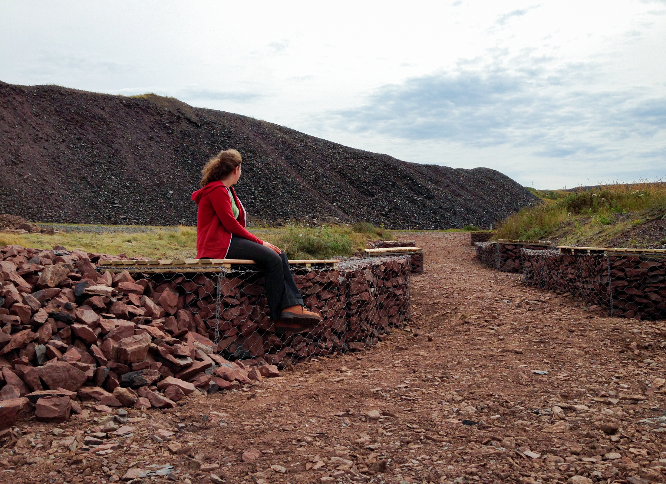 Person sitting on a chair of red rocks.
