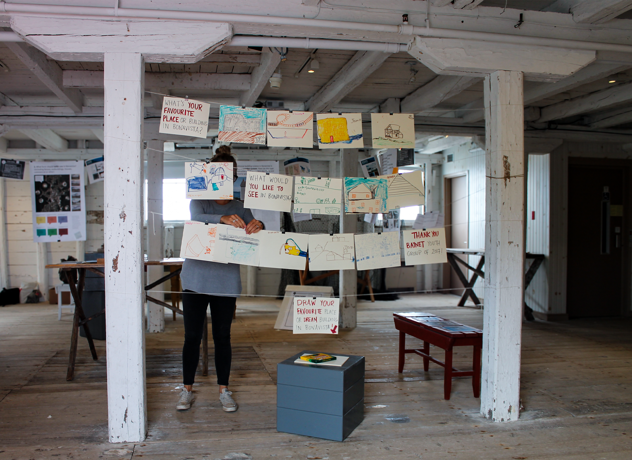 Inside an old building with children's drawings hanging up.