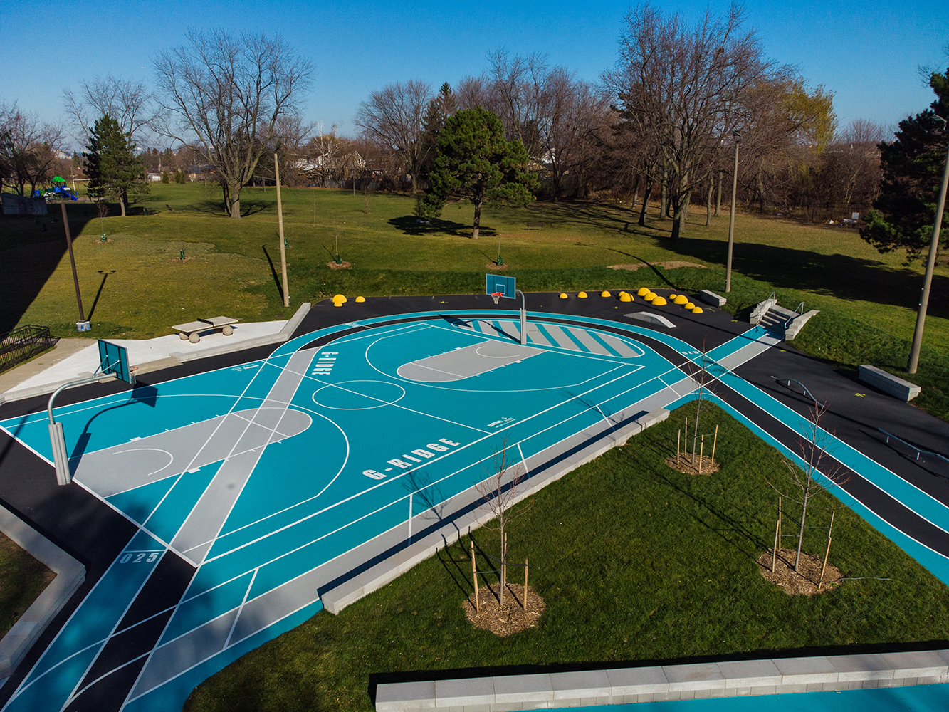 A wide view of Gordonridge's court with basketball hoops and walking track.