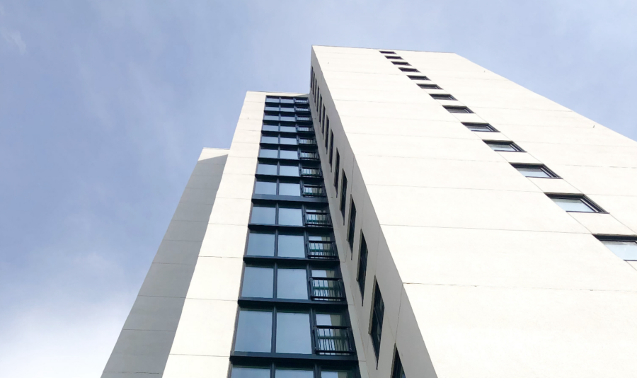 Ken Soble Tower, a white-clad 18-storey tower viewed from a vantage at ground level and looking high up into the sky.