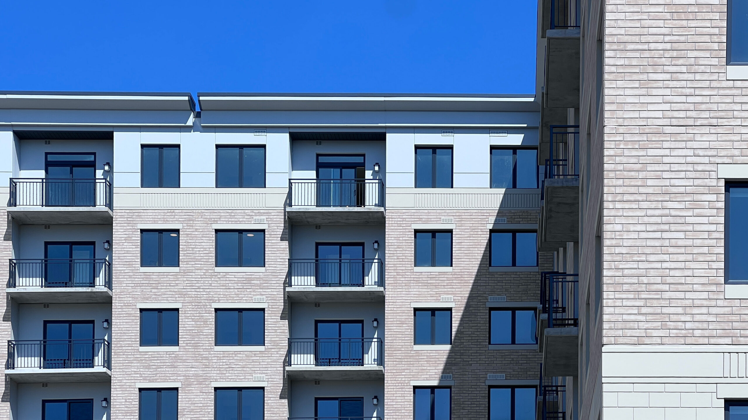 photo of numerous windows and balconies of a midrise building