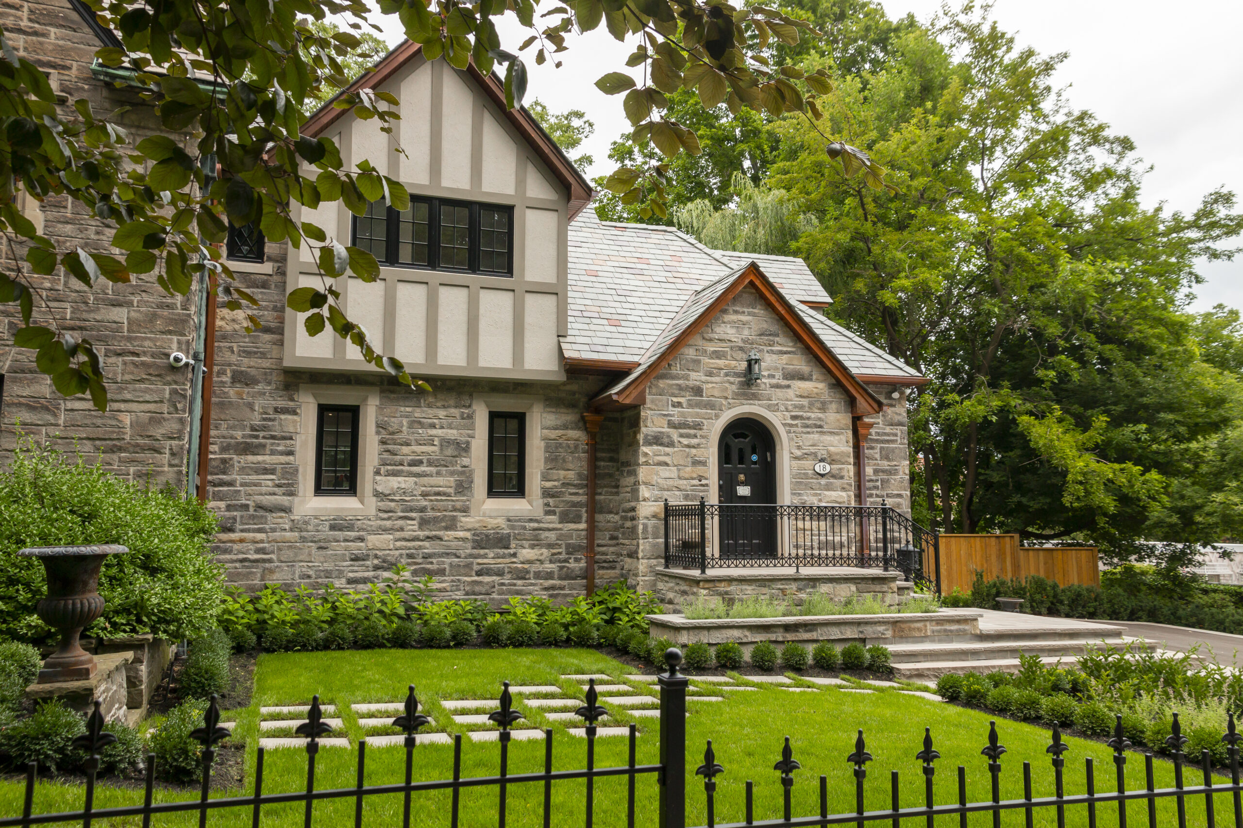 photo of a large stone house taken from an angle, surrounded by trees