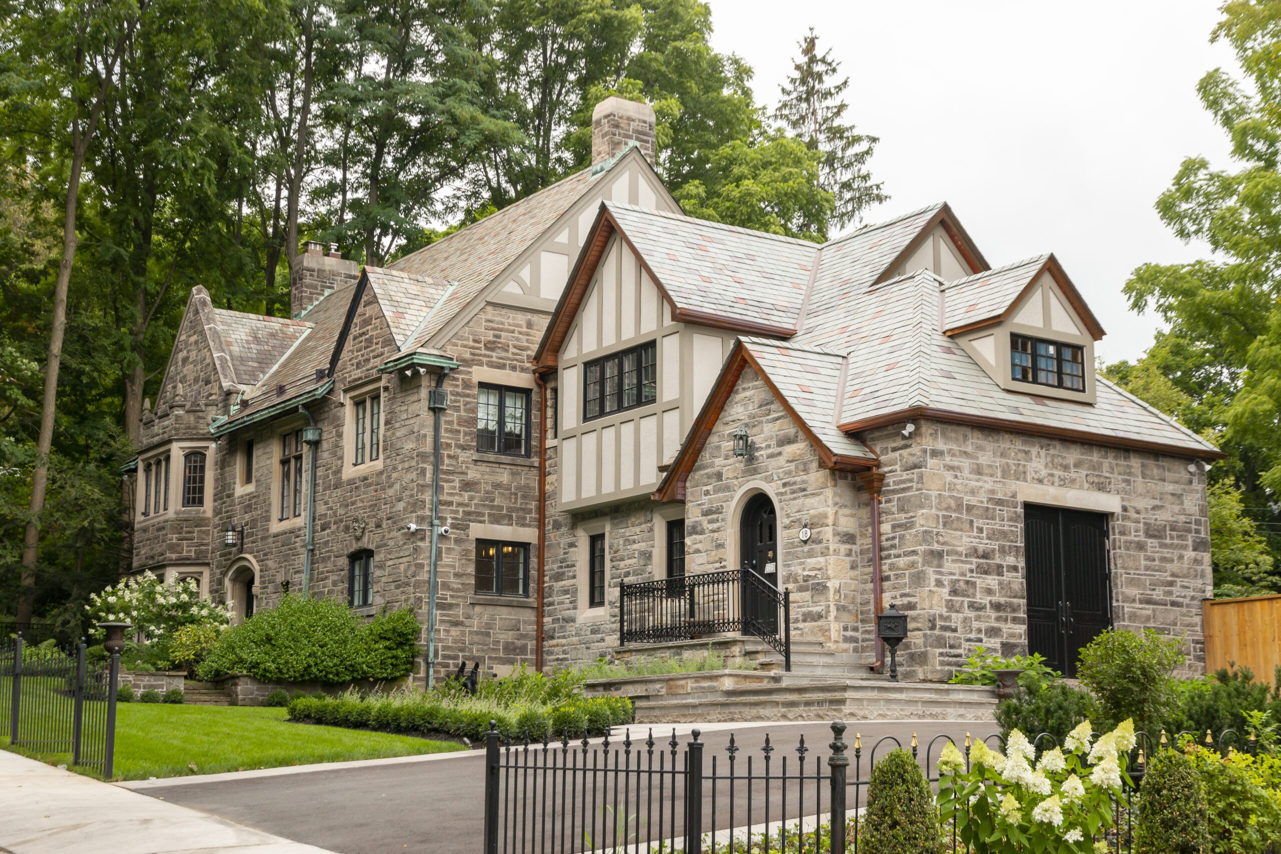 photo of a large stone house taken from an angle, surrounded by trees