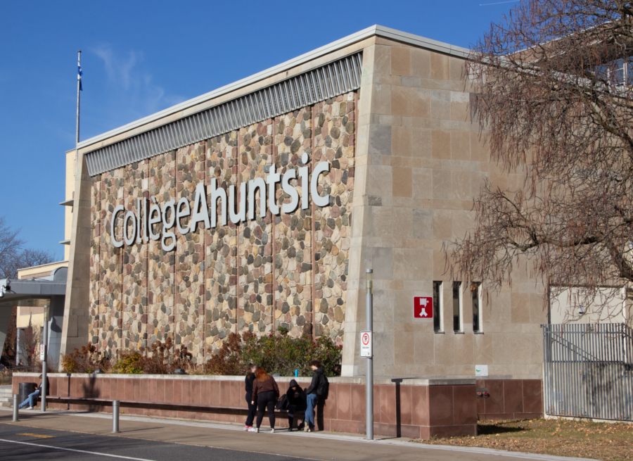 Exterior of Collège Ahuntsic, a concrete building in the background with trees and streets in the foreground.