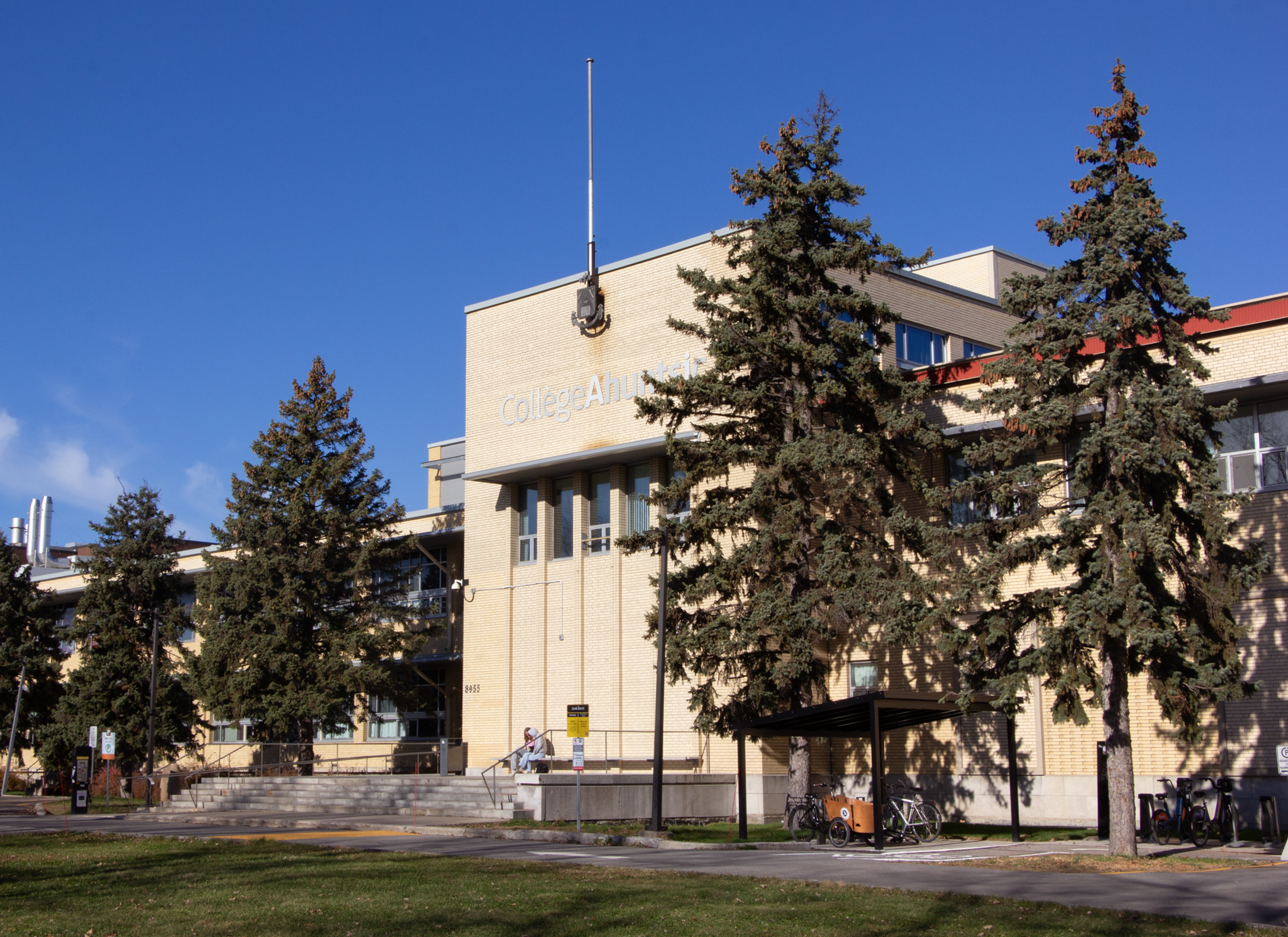 Exterior of Collège Ahuntsic with stairs, trees, and landscape.