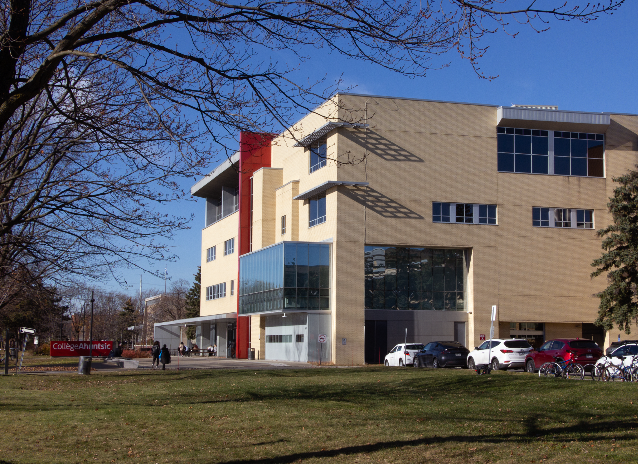 Exterior of Collège Ahuntsic with large red sign and landscape.