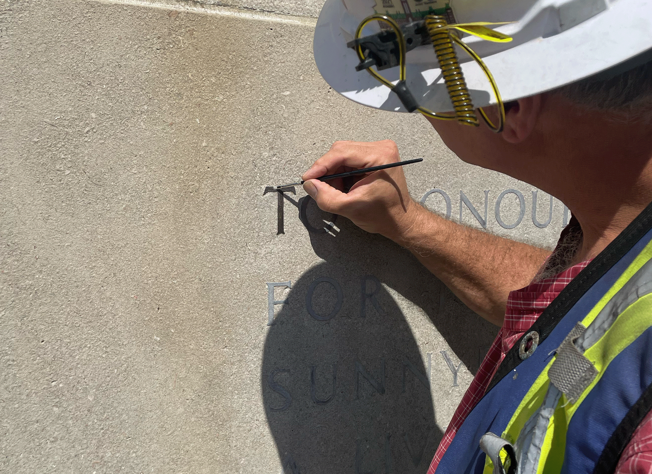 Person painting text on Sunnybrook Cenotaph.