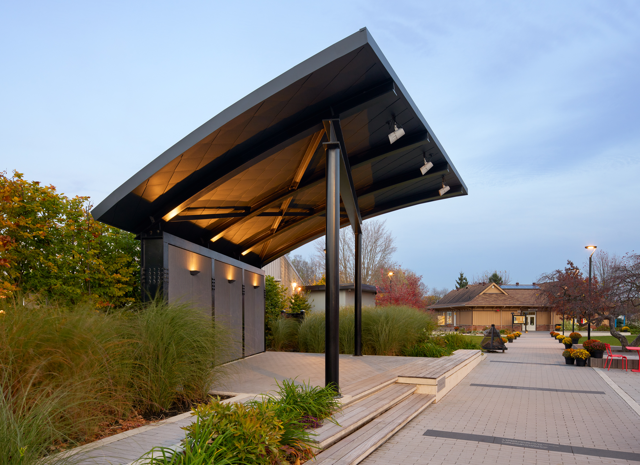 Pavilion with rounded roof surrounding by lush landscape.