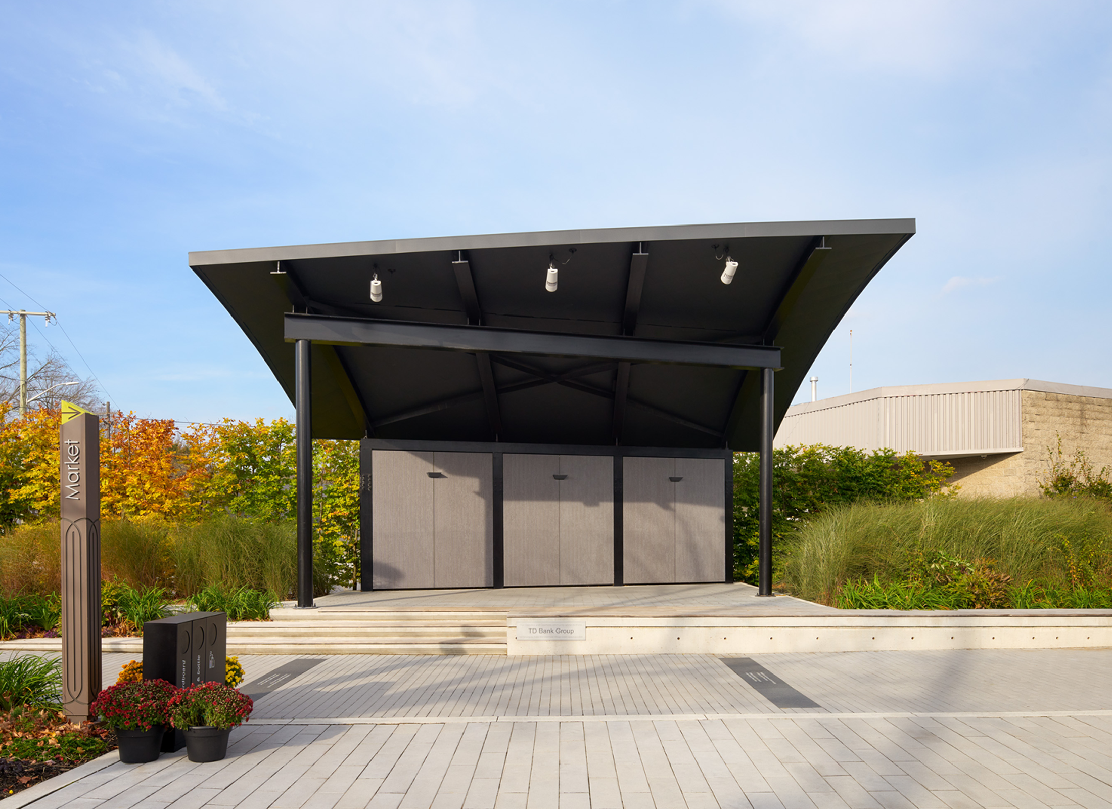 Pavilion with rounded roof surrounding by lush landscape.