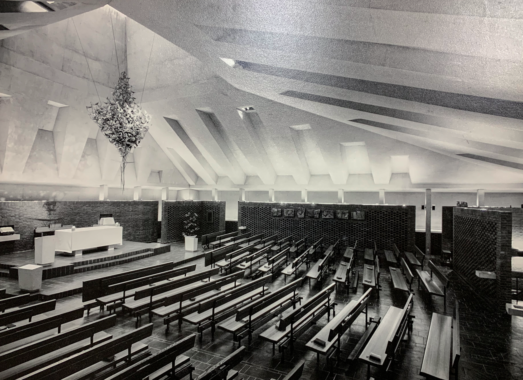 Interior of 1495 Heron Road chapel, a room with vaulted ceilings, pews, and a stage.
