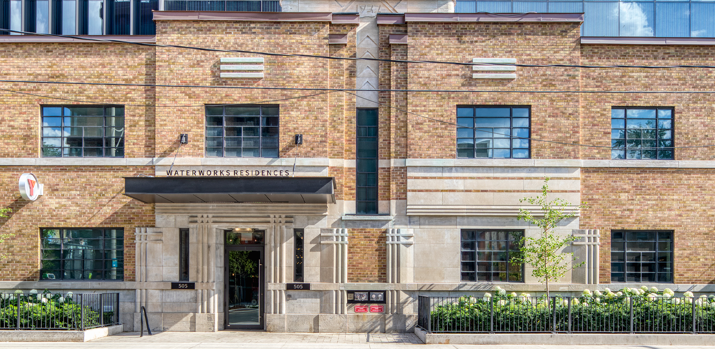 Elevation of the Waterworks building, a two-storey beige brick building with a taller glass building on top.