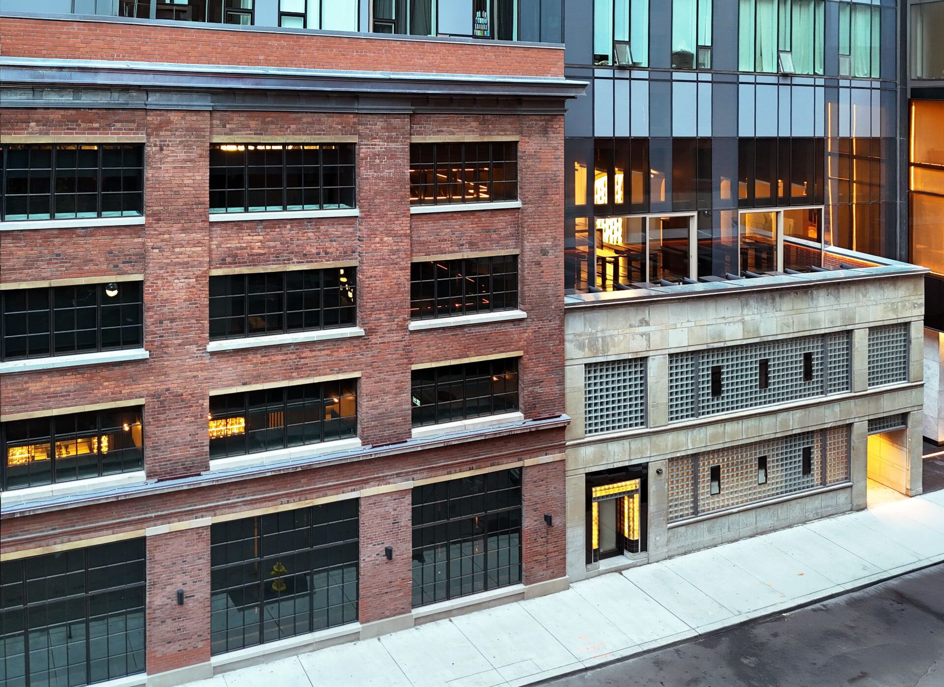 Exterior view of 15-30 Mercer, brick stone and glass block mid-rise buildings with large glass towers added on top.