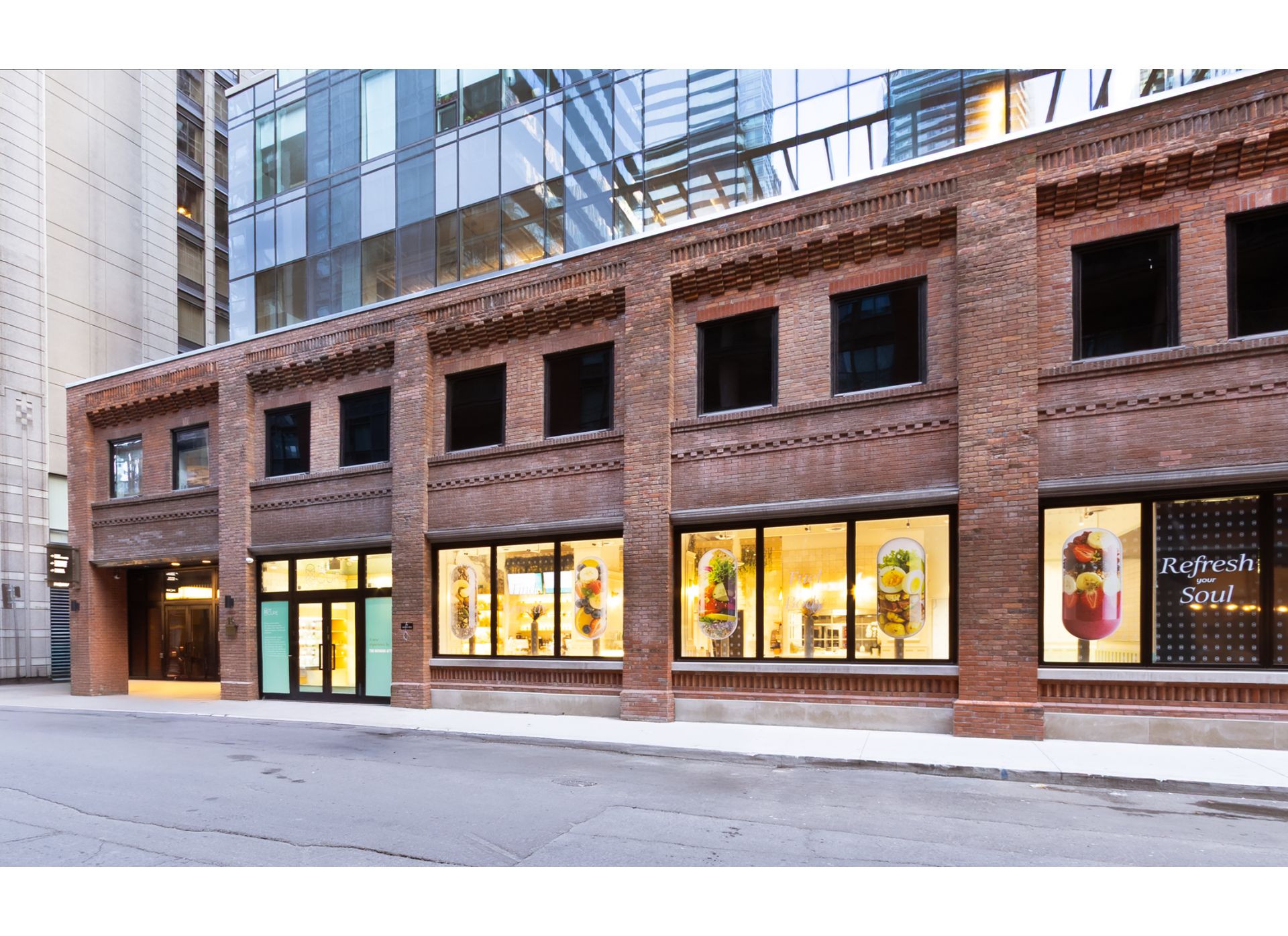 Mid-rise heritage brick building base with a large glass tower on top.