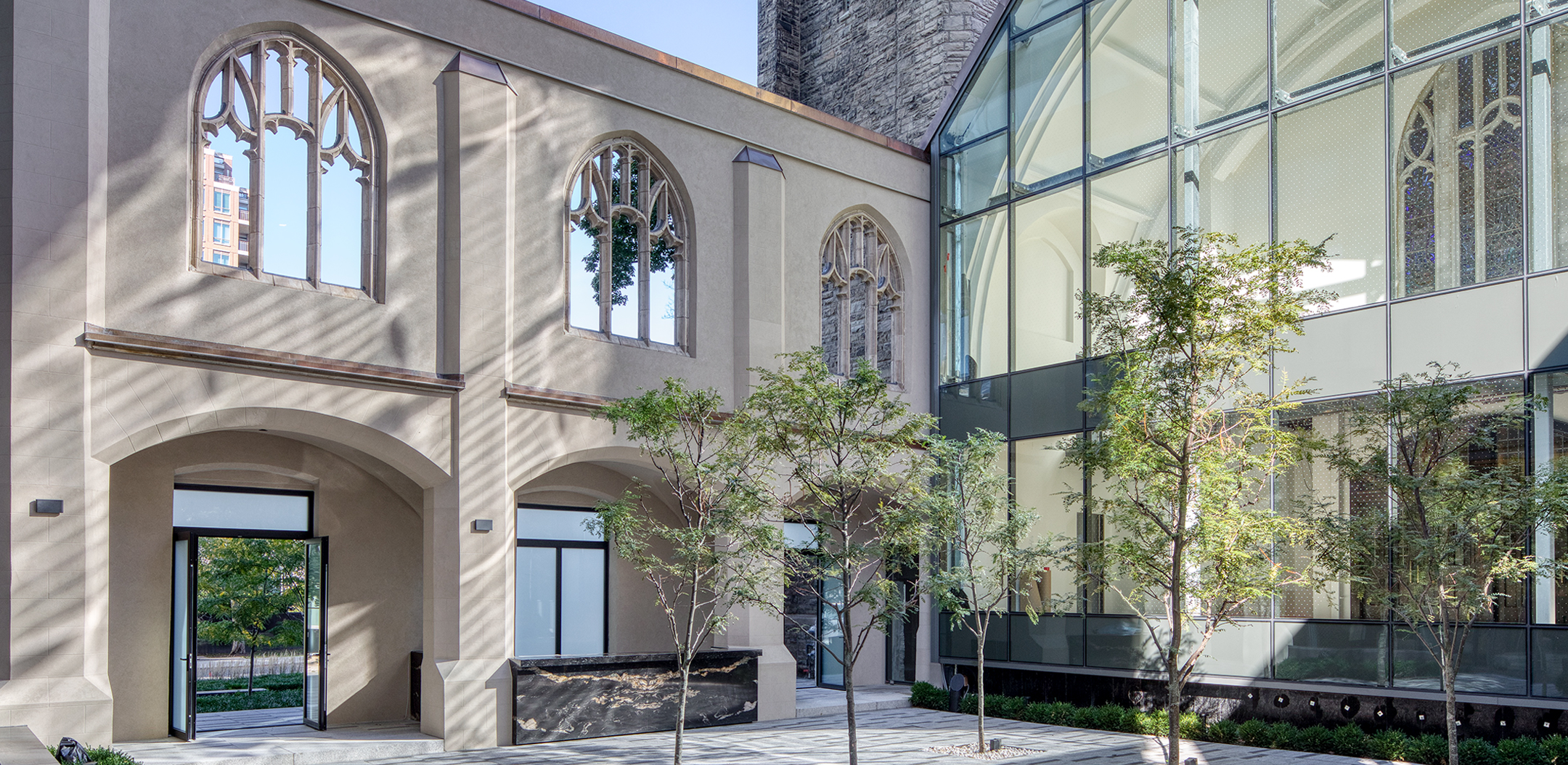 Courtyard of Deer Park Church with glass wall looking into church.